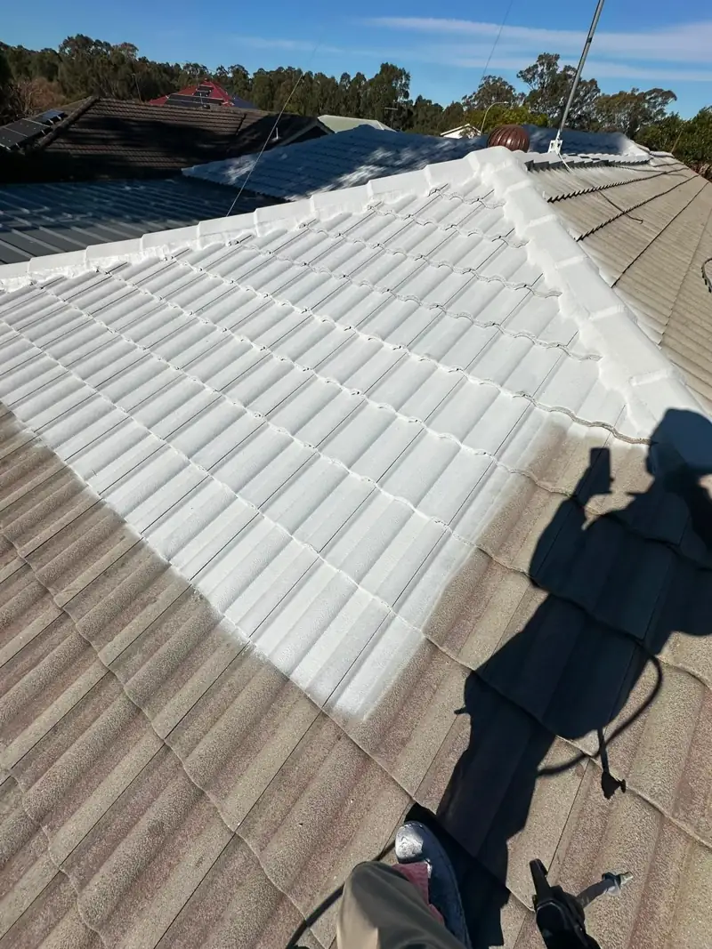 Primer being sprayed onto a cleaned concrete tile roof