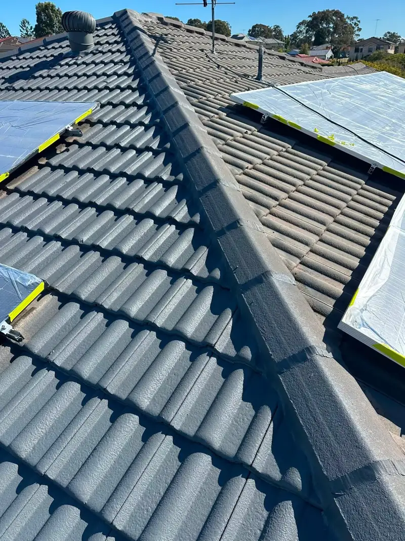 Ridge capping on a recoated tile roof with solar panels covered for protection