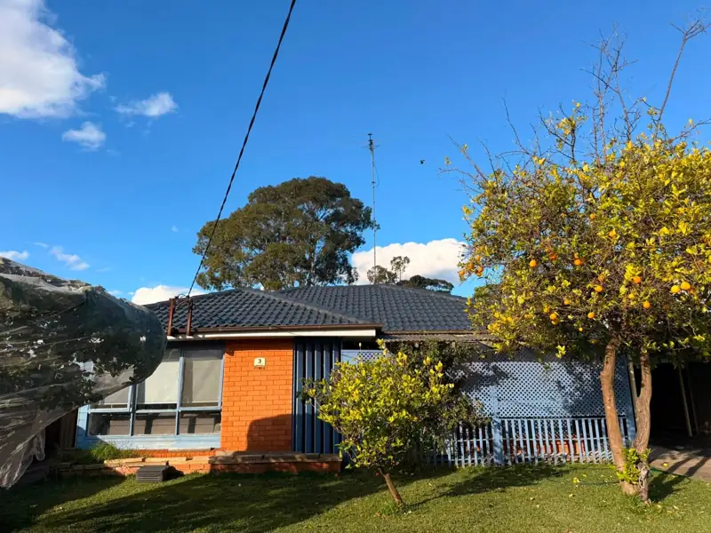 Brick home with a freshly coated dark tile roof